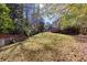 Expansive backyard space with a brick retaining wall and lush greenery at 6841 Fairway Ridge Dr, Douglasville, GA 30134