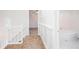 Bright hallway leading to a bathroom and bedroom with decorative wainscoting and white banister at 6841 Fairway Ridge Dr, Douglasville, GA 30134