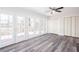 Spacious living room featuring a ceiling fan, wood-look floors, and three sets of exterior doors at 6841 Fairway Ridge Dr, Douglasville, GA 30134