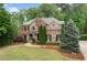 Expansive landscaped front yard featuring a mix of brick and stone work on this elegant two-story home at 893 Paces Farm Sw Trl, Marietta, GA 30064