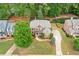 Aerial view of a brick home featuring manicured lawns, lush landscaping, and an attached three-car garage at 893 Paces Farm Sw Trl, Marietta, GA 30064