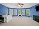 Bright bedroom with a bay of windows, ceiling fan, desk, chair, and a storage cabinet with neutral carpet at 893 Paces Farm Sw Trl, Marietta, GA 30064