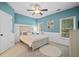 Well-lit bedroom with carpet, soft blue walls, white paneling, bed, ceiling fan, and two windows at 893 Paces Farm Sw Trl, Marietta, GA 30064