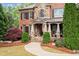 Charming brick and stone home featuring a covered front porch, manicured lawn, and American flag at 893 Paces Farm Sw Trl, Marietta, GA 30064