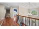 Open hallway with hardwood floors, stairs, chandelier, window, and doorway leading into another room at 893 Paces Farm Sw Trl, Marietta, GA 30064