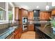 A kitchen with wood cabinets, stainless steel appliances, granite counters, and a mosaic backsplash at 893 Paces Farm Sw Trl, Marietta, GA 30064