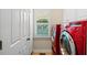 Bright laundry room with red washer and dryer and natural light from the window at 893 Paces Farm Sw Trl, Marietta, GA 30064