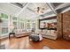 Beautiful living room with hardwood floors, a stone wall, and backyard views through many windows at 893 Paces Farm Sw Trl, Marietta, GA 30064