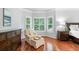A comfortable chair and ottoman in a primary bedroom bay window creates a cozy sitting area at 893 Paces Farm Sw Trl, Marietta, GA 30064