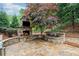 Stunning outdoor living space featuring a stone fireplace with TV and a stone water feature on a stone patio at 893 Paces Farm Sw Trl, Marietta, GA 30064