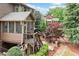 Rear exterior view of a multi-story home featuring a screened in porch and outdoor fireplace and water feature at 893 Paces Farm Sw Trl, Marietta, GA 30064