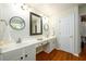 Bright bathroom with double sinks, white cabinets, and a large mirror at 3545 River Summit Trl, Duluth, GA 30097