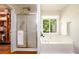 Bathroom with a glass shower, soaking tub, and a window with natural light at 3545 River Summit Trl, Duluth, GA 30097