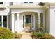 Elegant front entrance with white columns, a decorative storm door, and manicured landscaping at 3545 River Summit Trl, Duluth, GA 30097