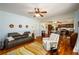 Comfortable living room area with wood floors, ceiling fan, and open view to the kitchen at 3545 River Summit Trl, Duluth, GA 30097