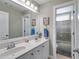 Bathroom vanity featuring a double sink, large mirror, and a view of the shower and commode at 36 Evergreen Way, Dallas, GA 30157