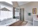Bright bathroom featuring a soaking tub with tile surround and a glass enclosed shower at 36 Evergreen Way, Dallas, GA 30157
