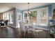 Sunlit dining area with a white table, matching chairs, and large windows offering backyard views at 36 Evergreen Way, Dallas, GA 30157