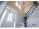 Bright entryway features high ceilings, a chandelier, staircase with iron railing, and a front door with glass panels at 36 Evergreen Way, Dallas, GA 30157