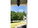 View of a manicured front yard with a walkway leading to a charming home surrounded by lush trees and a blue sky at 36 Evergreen Way, Dallas, GA 30157