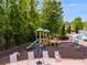 Outdoor playground with a slide and play equipment is adjacent to a pool with lounge chairs at 36 Evergreen Way, Dallas, GA 30157
