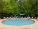 A circular pool with water features surrounded by lounge chairs and lush greenery offers a peaceful retreat at 36 Evergreen Way, Dallas, GA 30157
