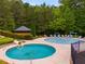 Community pool area featuring pools with slides and fountains, a covered picnic area, and lounge chairs for relaxation at 36 Evergreen Way, Dallas, GA 30157