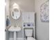 Stylish powder room with pedestal sink, white cabinet, oval mirror, and elegant blue accents at 36 Evergreen Way, Dallas, GA 30157