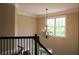Elegant staircase with black iron railing and a decorative chandelier by the window at 36 Evergreen Way, Dallas, GA 30157