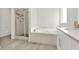 Modern bathroom featuring a glass shower, soaking tub, and stylish gray tile flooring at 6859 Winding Wade Trl, Austell, GA 30168