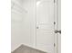 Bright closet with neutral carpet, built-in shelving, and a white door at 6859 Winding Wade Trl, Austell, GA 30168