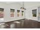 Bright dining room with dark hardwood floors, three windows, modern lighting, and access to the backyard at 6859 Winding Wade Trl, Austell, GA 30168