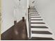 Inviting entryway with dark hardwood floors, staircase, and a glimpse of the living room fireplace at 6859 Winding Wade Trl, Austell, GA 30168