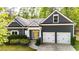 Charming home with a two-car garage, neat landscaping, and a welcoming yellow front door at 6859 Winding Wade Trl, Austell, GA 30168