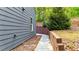 Side view of gray home with small yard, retaining wall, and sidewalk leading to backyard at 6859 Winding Wade Trl, Austell, GA 30168