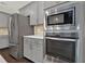 The kitchen features stainless steel appliances, gray cabinets, and a tiled backsplash at 6859 Winding Wade Trl, Austell, GA 30168