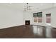 Spacious living room features dark hardwood flooring, modern light fixture, and fireplace at 6859 Winding Wade Trl, Austell, GA 30168