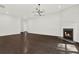 Spacious living room with dark hardwood flooring, fireplace, and modern light fixture at 6859 Winding Wade Trl, Austell, GA 30168