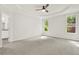 Spacious main bedroom with plush carpet, ceiling fan, and ample natural light from two large windows at 6859 Winding Wade Trl, Austell, GA 30168
