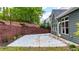 Backyard featuring a concrete patio, grass, mature trees, and dark gray siding at 6859 Winding Wade Trl, Austell, GA 30168