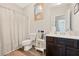 Well-lit bathroom features a shower with patterned curtain and dark wood vanity at 1129 Abundance Dr, Locust Grove, GA 30248