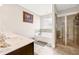 Elegant bathroom with a double vanity, soaking tub, separate glass-enclosed shower, and tile flooring at 1129 Abundance Dr, Locust Grove, GA 30248