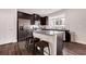 Modern kitchen featuring granite countertops, dark cabinets, stainless steel appliances, and bar seating at 1129 Abundance Dr, Locust Grove, GA 30248