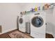 Clean and organized laundry room with washer, dryer and overhead storage at 1129 Abundance Dr, Locust Grove, GA 30248
