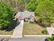 Aerial view of a well-maintained home with a long driveway and lush, mature trees surrounding the property at 1670 Bookhout Dr, Cumming, GA 30041