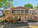 Back of brick home with elevated screened porch, wooden deck with stairs, and patio space at 1670 Bookhout Dr, Cumming, GA 30041