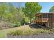 A backyard featuring a multi-level deck, a spacious yard, and beautiful, mature trees at 1670 Bookhout Dr, Cumming, GA 30041