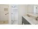 Bathroom with a shower, double sink vanity, and view to the backyard at 1670 Bookhout Dr, Cumming, GA 30041