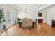 Dining room features hardwood floors, a wooden table with seating, and a modern chandelier at 1670 Bookhout Dr, Cumming, GA 30041
