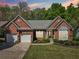 Inviting brick home with a well-manicured lawn, a two-car garage, and charming landscaping in the front yard at 1670 Bookhout Dr, Cumming, GA 30041